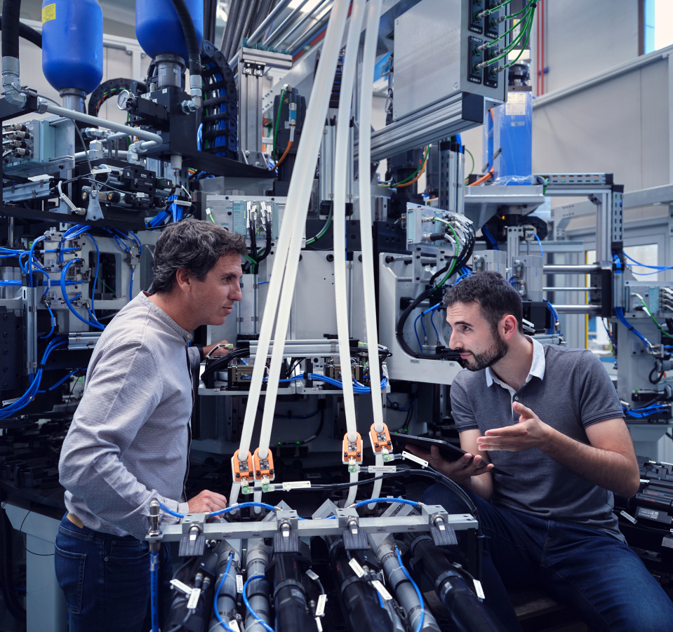 Project manager explaining deadlines to engineer on connecting rod cracking machine.